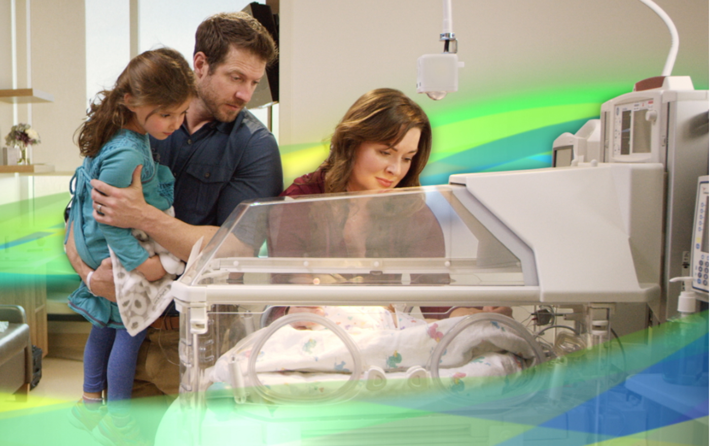 family visiting infant in incubator
